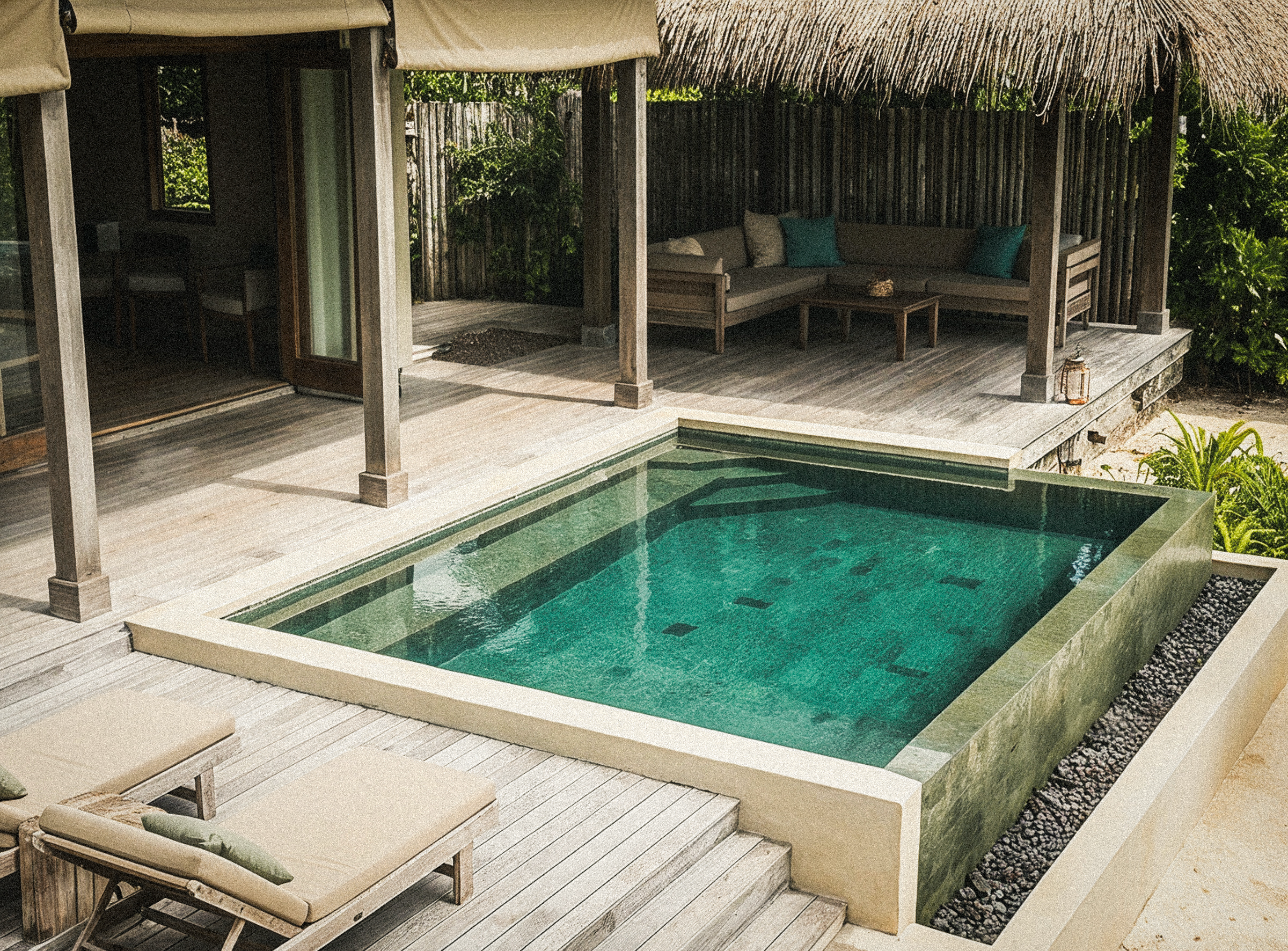 A plunge pool with stone steps, shaded by a thatched-roof cabana at Casa Vireya.