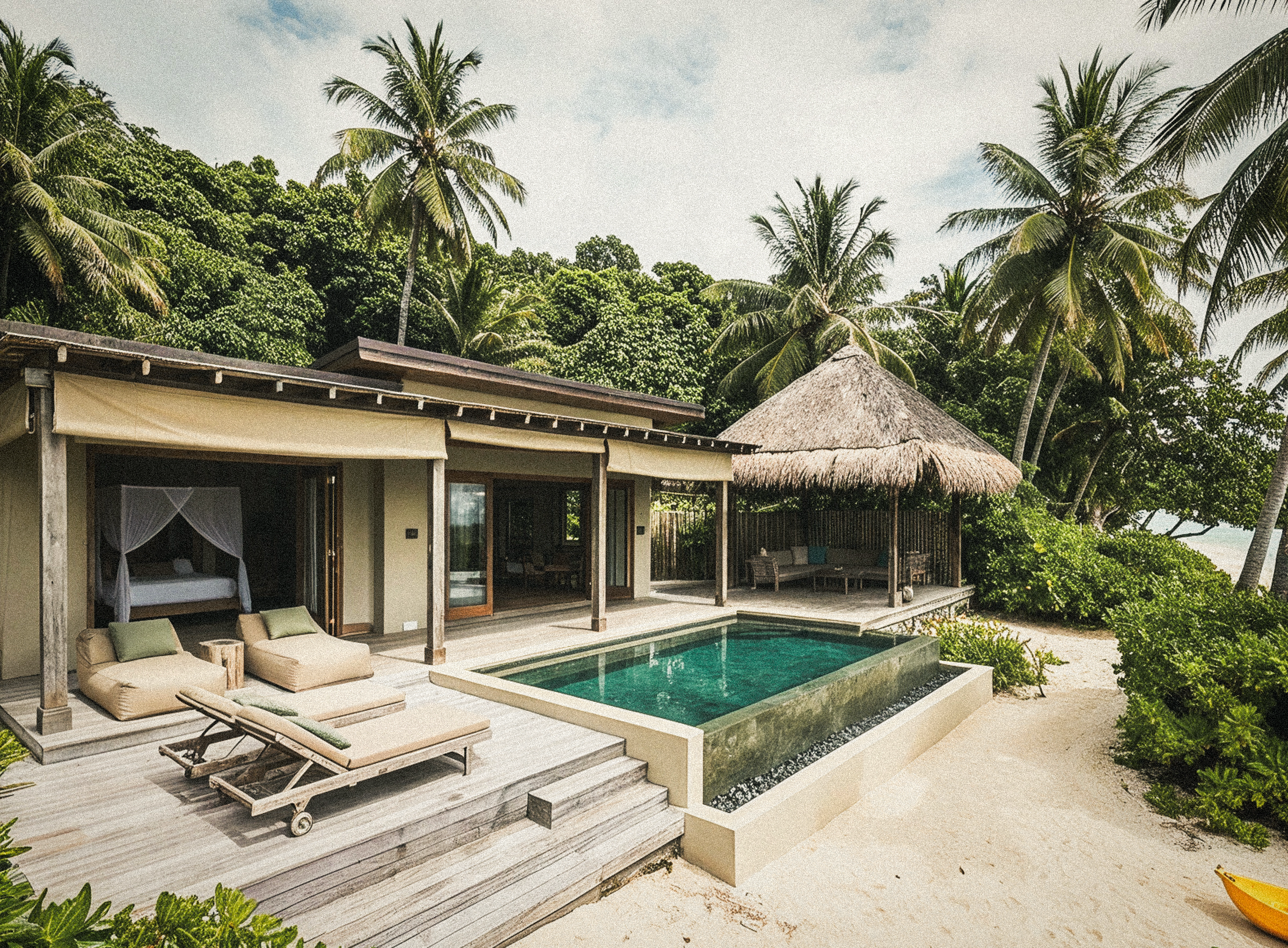 Wide exterior view of the villa with its thatched cabana, plunge pool and surrounding palms.