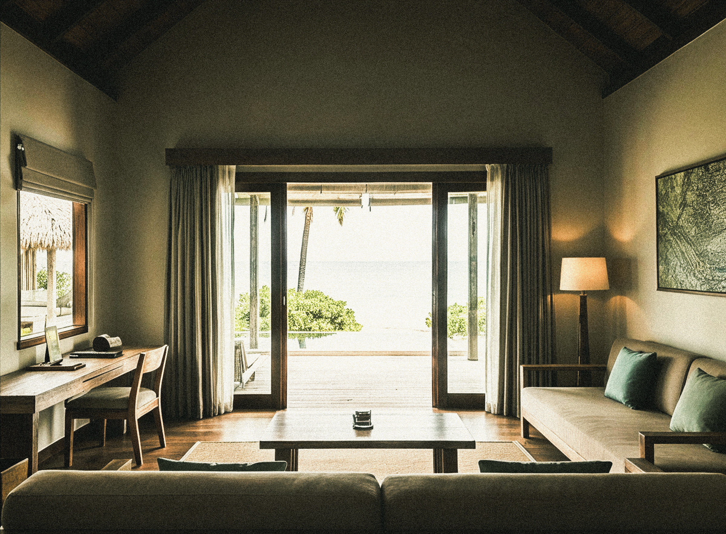 Living room of Casa Vireya with sliding glass doors open to a private infinity pool and the ocean beyond.
