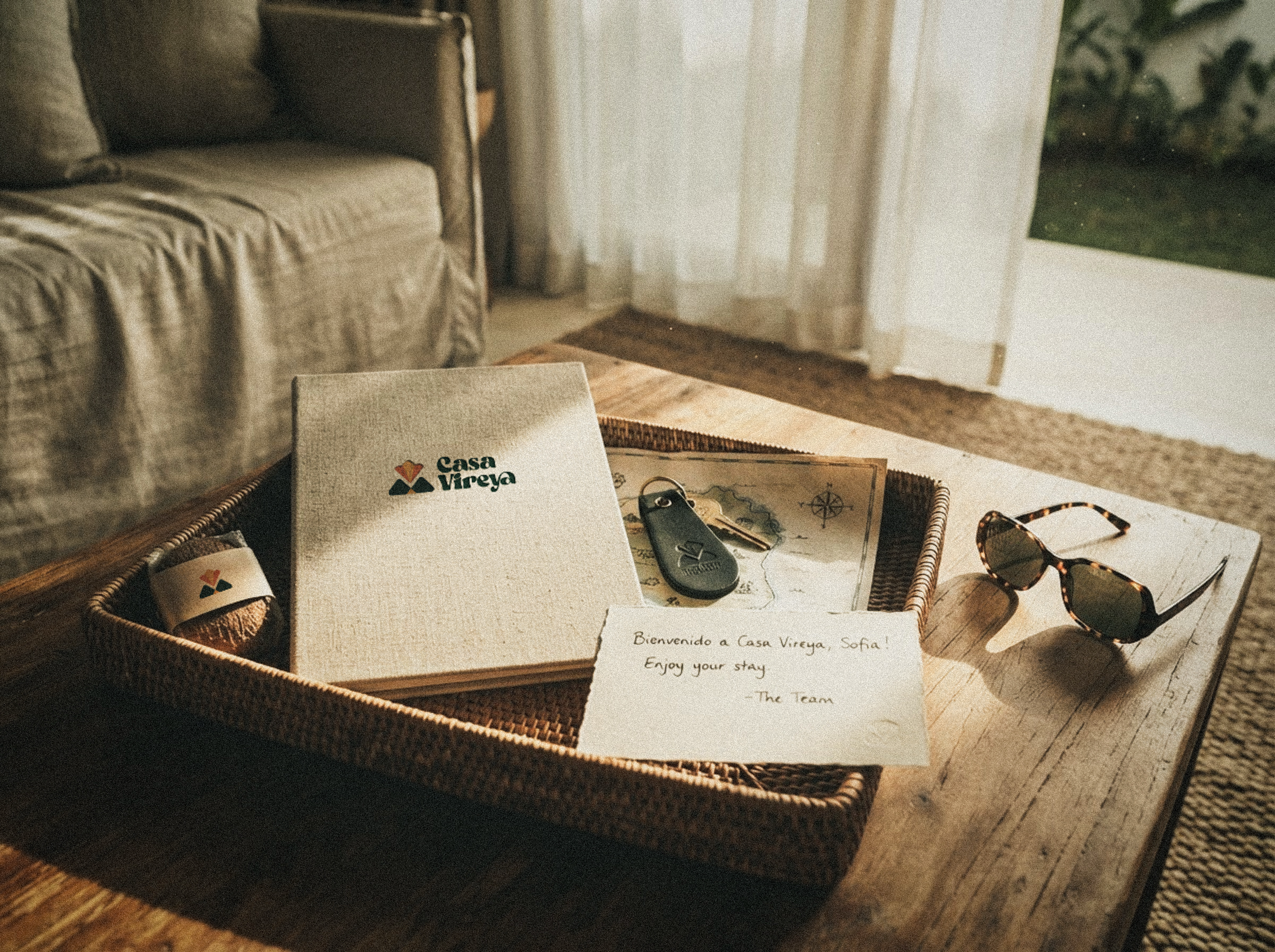 A welcome tray with a linen guidebook, brass key, hand-drawn map and a handwritten note.